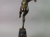 bronze statue of a boy on a marble base holding a tennis racquet