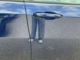 a reflection of a person standing in the door of a car
