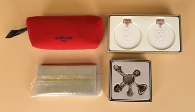 un écrin rouge contenant une paire de boucles d'oreilles et deux montres-bracelets