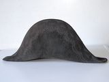 gray hat on a white surface with a white wall in the background
