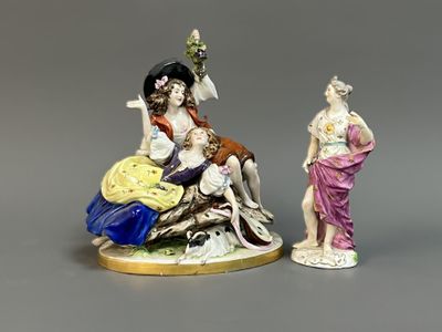 two figurines of women sitting on a rock with flowers in their hair