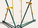 trois outils de chantier verts et jaunes posés sur une surface blanche