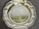 une assiette en argent ornée d'un motif décoratif sur le bord