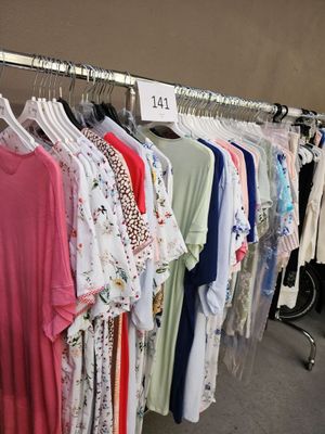 beaucoup de chemises suspendues à un portant dans un magasin
