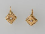a pair of gold and pearl earrings