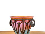 a colorful vase sitting on top of a wooden table