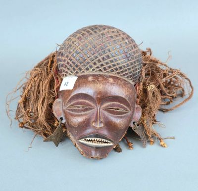 un gros plan d'un masque en bois sur un fond bleu