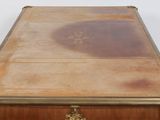a wooden table with a glass top and gold trimmings