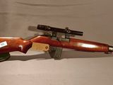 un fusil en bois surmonté d'un canon, posé sur une surface blanche