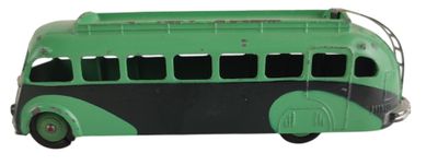 un petit bus jouet vert et noir posé sur une surface blanche