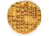 a wooden plate with gold beads on it on a white surface