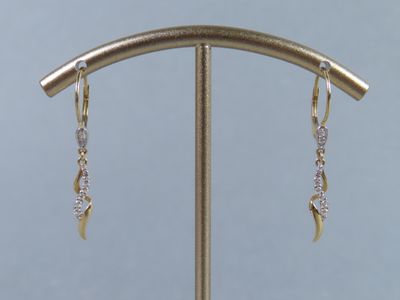 boucles d'oreilles en argent et plaquées or, présentées sur un présentoir avec un fond bleu