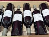 six bottles of wine are in a wooden box on a table