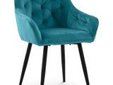 une chaise bleu sarcelle aux pieds noirs, avec une assise rembourrée et capitonnée