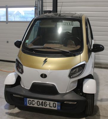 une petite voiture blanche et dorée garée dans un garage
