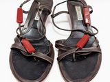 une paire de sandales noires et rouges avec des lanières rouges sur un fond blanc