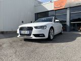 L'Audi blanche est garée devant un immeuble.
