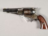 an old revolver with a wooden handle on a white surface