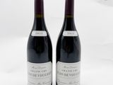 deux bouteilles de vin rouge posées sur une surface blanche