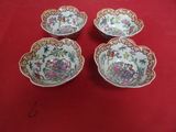 four bowls with floral designs on them on a red surface
