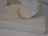 a statue of a person standing on top of a piece of paper