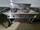 a stove top with two burners on it in a kitchen