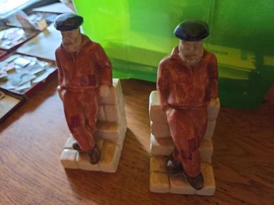 two figurines of two men sitting on a bench
