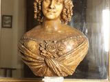 a bust of a woman sitting on a table in front of a mirror
