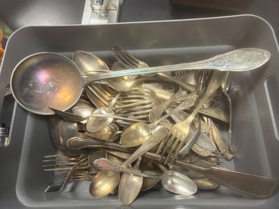 many silver spoons and spoon spoons in a container