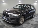 the bmw x1 is parked in a showroom with a checkered floor