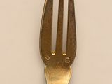 a fork with a flower on it on a white surface
