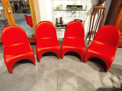 quatre chaises rouges sont alignées en rang devant un miroir