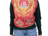the woman is wearing a sweater with a coat of arms on it