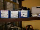 several boxes of electronic equipment sit on a shelf in a room