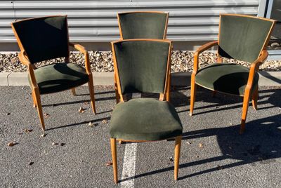 trois chaises vertes posées sur un parking à côté d'un immeuble
