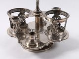 a silver plate with a silver candle holder on it