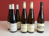 six bouteilles de vin sont alignées sur une table