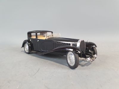 an old model of a black car on a white surface