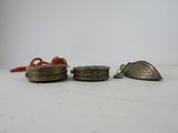 three small metal objects sitting on top of a white surface