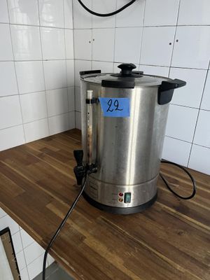 une cafetière en acier inoxydable posée sur un plan de travail en bois