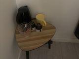 a small table with a bowl on it in a small room