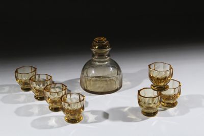 six verres et une carafe posés sur une table