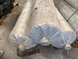 many rolls of metal sitting on a pallet in a warehouse