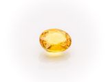 a yellow sapphire stone on a white background