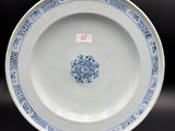 blue and white plate with a floral design on the rim