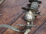 pair of antique brass wall sconces on a wooden floor