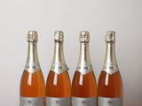 trois bouteilles de champagne posées sur une table l'une à côté de l'autre