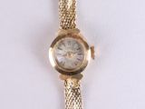 une image d'un gros plan d'une montre-bracelet sur une surface blanche