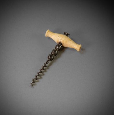 a close up of a bottle opener with a wooden handle on a gray surface