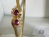gold plated bangle with ruby stones and cubicles on display in a box
